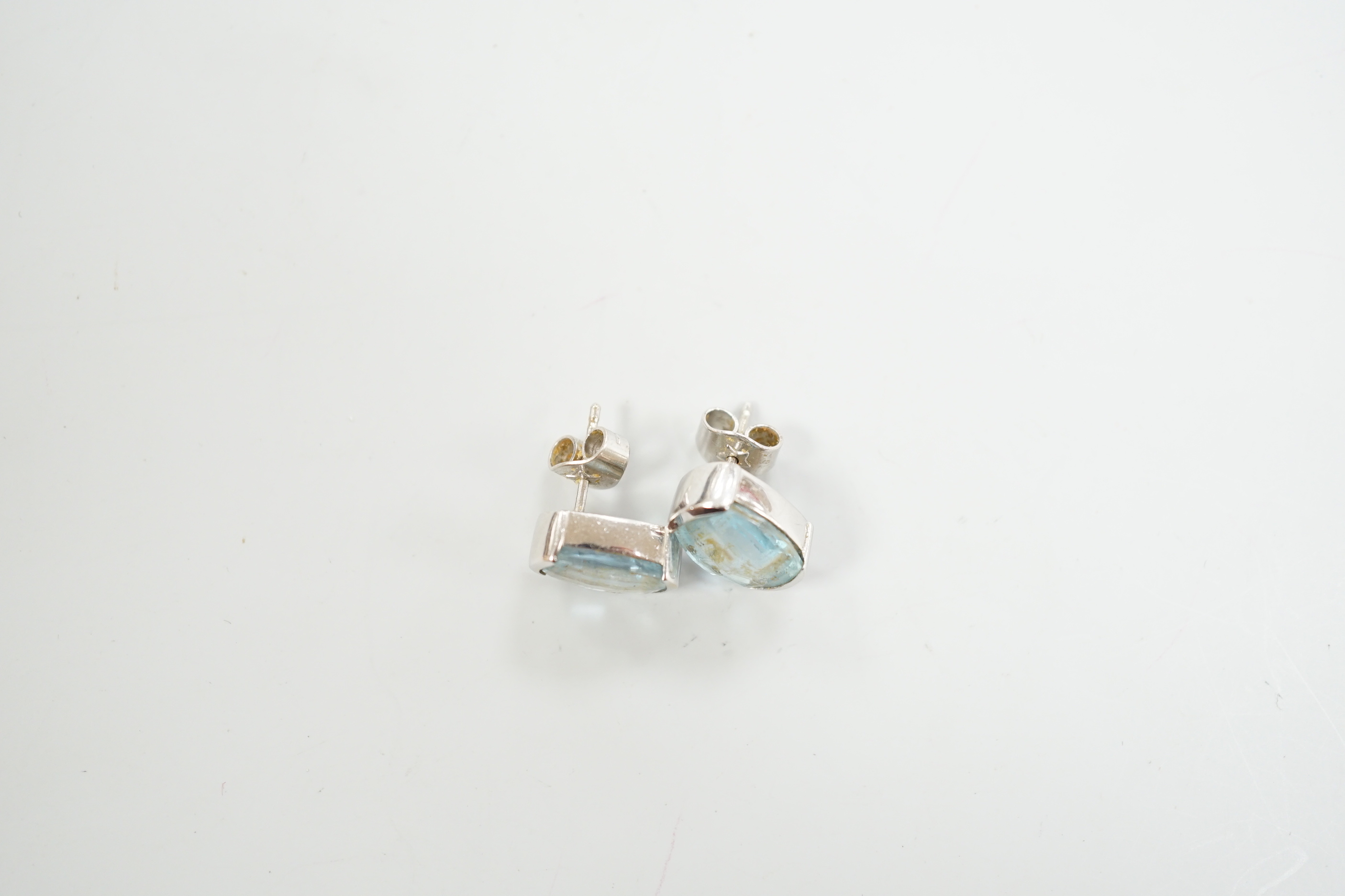 A modern pair of 750 white metal and single stone blue topaz set ear studs, length 13mm, gross weight 5.6 grams.